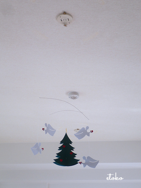 天井から紙製のツリーと天使のモビールが吊り下げられている